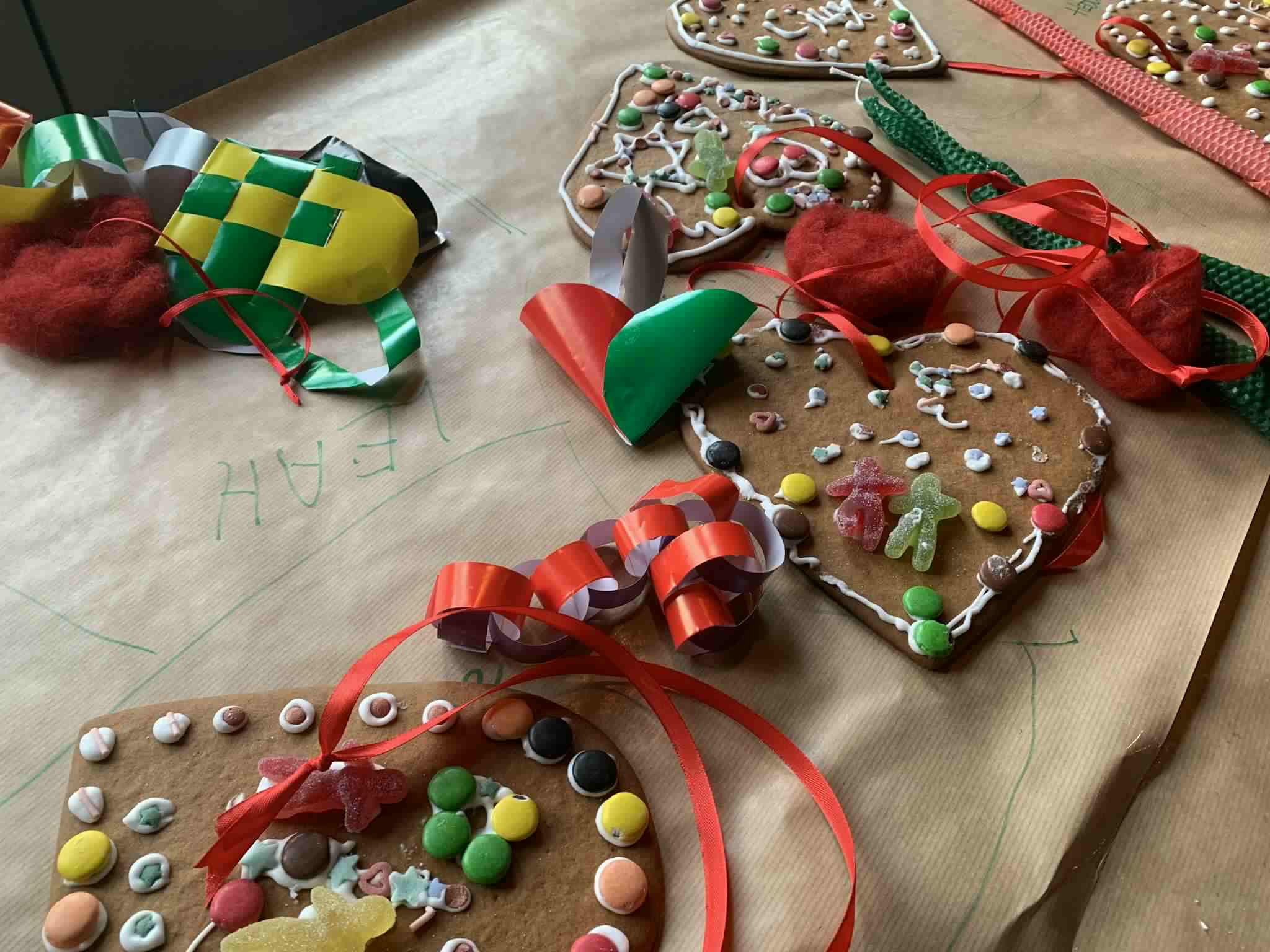 pepperkakehjerter pyntet med melis og nonstopp, og julelenker og hjerter av glanspapir